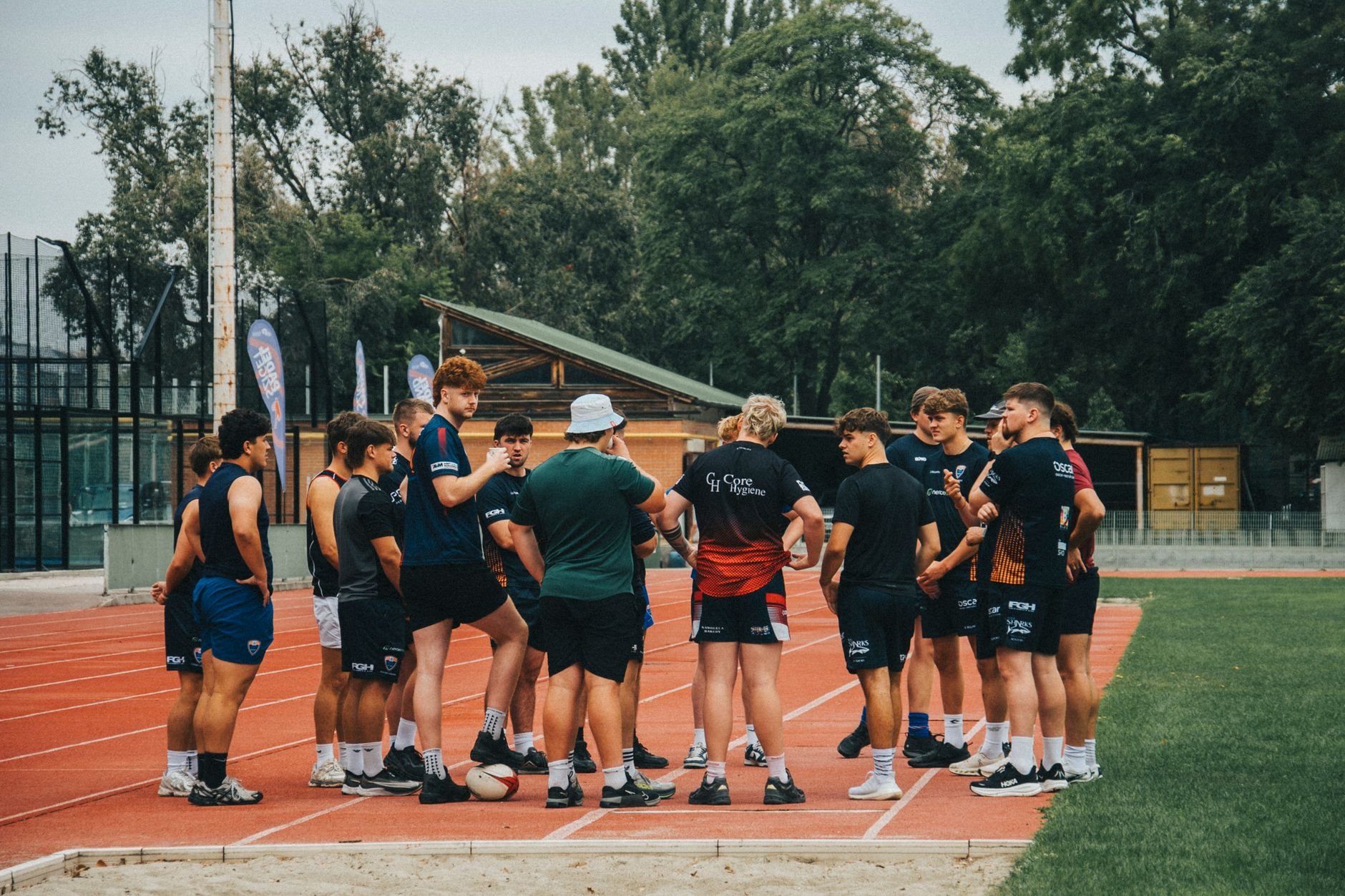 Group of young athletes in a team huddle on an outdoor running track